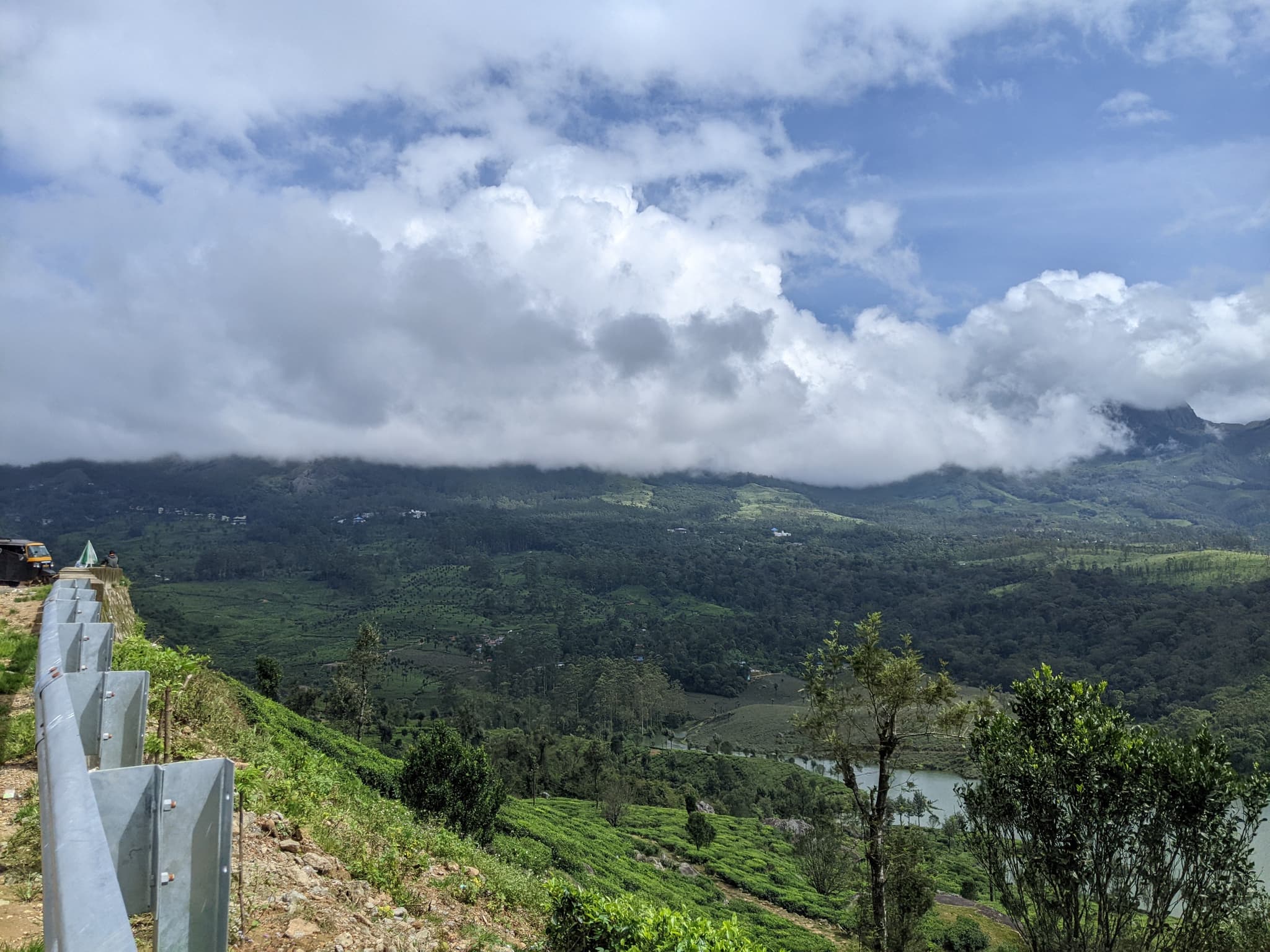 Mountain valley with tea plantations, clouds wrapping around peaks